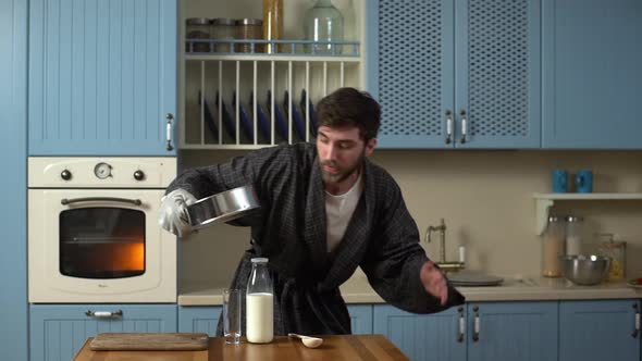 Portrait of Young Man 20s Wearing Housecoat Cooking Delicious Cheesecake or Pastry for Breakfast at alt
