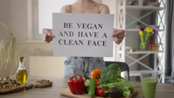 Front View Unrecognizable Woman Showing Be Vegan and Have a Clean Face Standing Indoors alt