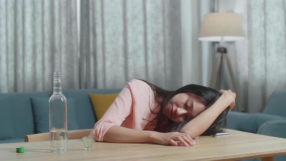 Drunk Asian Woman With Smartphone On Table Drinking Vodka And Sleeping At Home alt