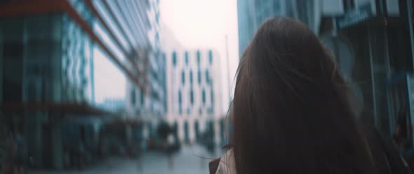 Woman walks between buildings alt