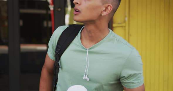 Mixed race man holding coffee, rising his hand up in the street alt
