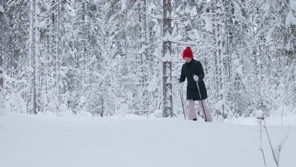 A woman walking through deep snow in forest