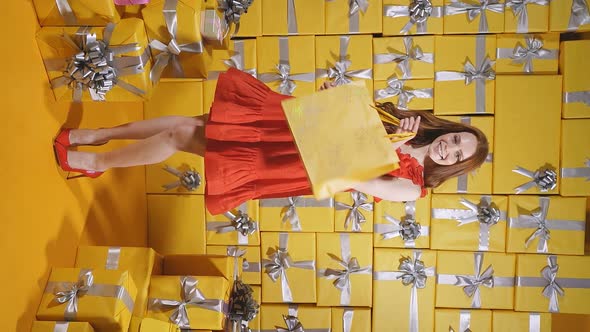A Young Lady in Elegant Red Clothes Surrounded By Gift Boxes Gifts