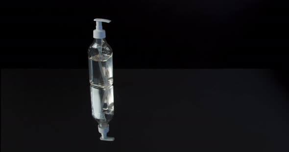 Man Push Dispenser and Liquid Soap Squeezed Out To Hand, Closeup Shot Against Black Background.  alt