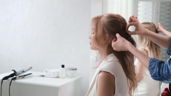 Female Stylist Finishing Hairstyle with Plaiting and Curly Styling alt