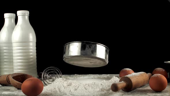 Super Slow Motion Sieve Falls Into a Pile of Flour on the Table alt