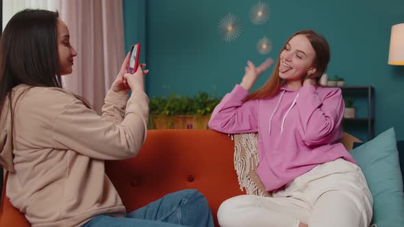 Lovely Girls Friends Siblings Taking Photo Pictures of Each Other on Smartphone for Social Media alt