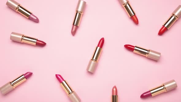 Pink lipsticks moving on pink background - Stop motion.