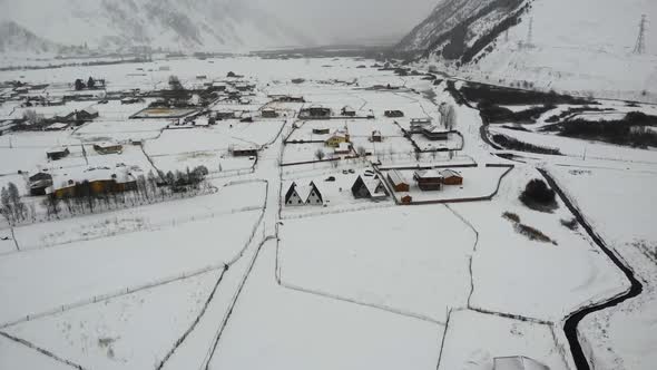 Drone Motion of Snowy Mountains Village. alt