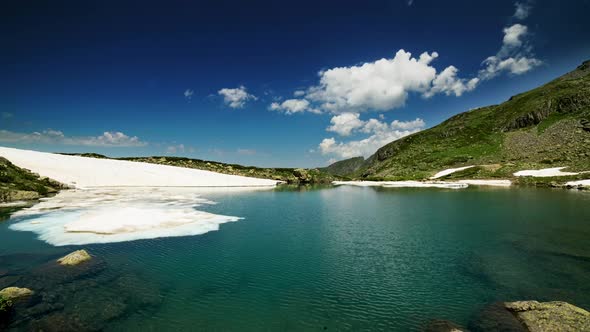 4K Unmelted Snow. Glacial lake Time Lapse on top of mountains.