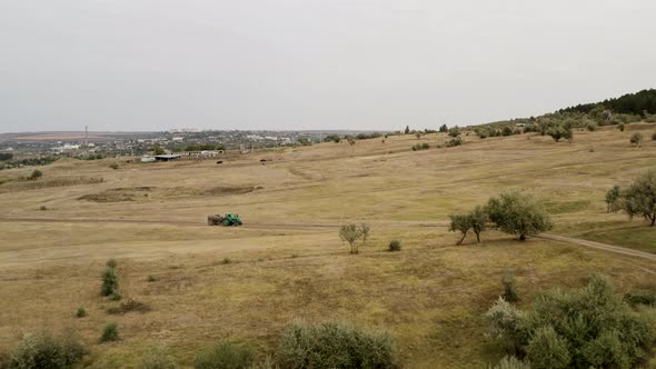 Aerial View of Green Tractor Driving Through the Field