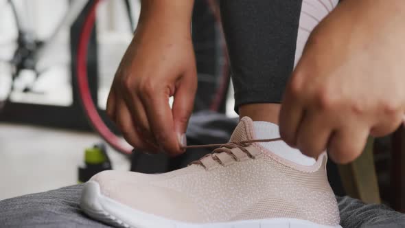 Video of foot of plus size african american woman in sport clothes tying shoes alt