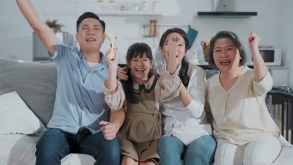 Portrait of Asian happy family sitting and looking at camera with smile together at home together. alt