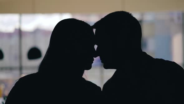 Enamored сouple are flirting in the restaurant on the background of the window. alt