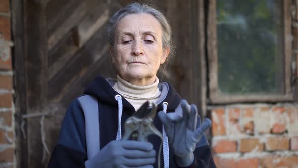 Senior Woman is Clearing a Garden Pruner for Trimming the Bushes in Her Garden Happy Retirement alt