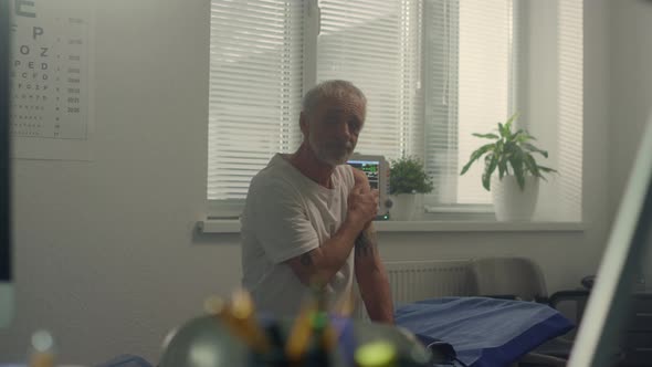 Doctor Sitting Work Desk Consulting Senior Patient After Vaccination in Hospital alt