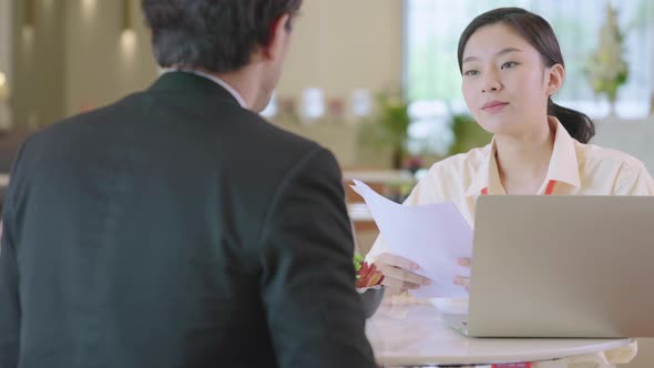 asian businessman and woman discuss together with laptop in modern office design alt
