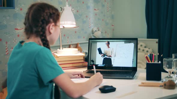 Little Girl Attending School Class Remotely Using Her Laptop. Remote Education Caused By the Covid alt
