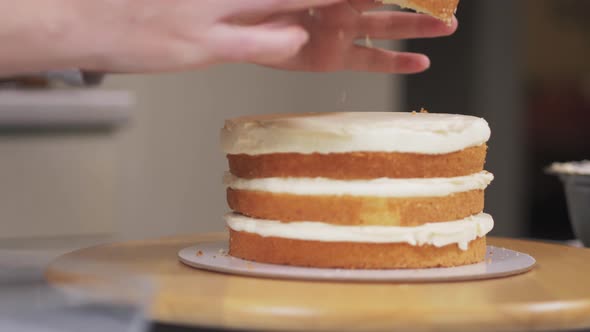 The Pastry Chef Puts the Fourth and Last Layer of Sponge Cake alt