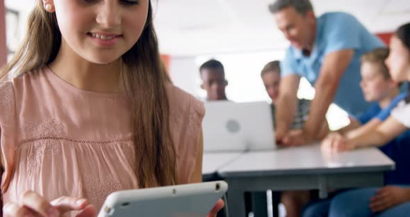 Portrait of happy schoolgirl using digital tablet 4k alt