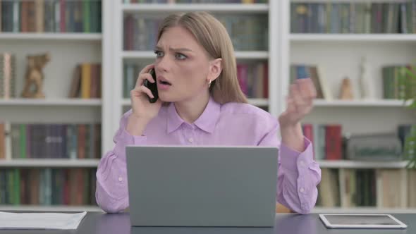 Angry Woman Talking on Phone at Work alt