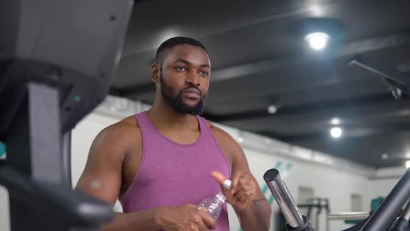 African American Man Drinking Water After Training in the Gym alt