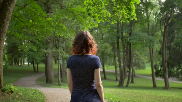 Middle View of Young Beautiful Girl, Unfolding Into the Camera in the Park alt