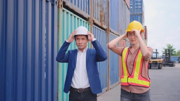 Cargo container worker man and woman wear hardhat together and walk to back direction