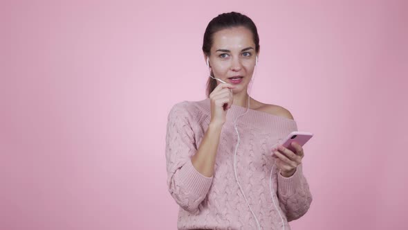 Woman Talking on Video Chat Using Mobile Phone Isolated on Pink Background alt