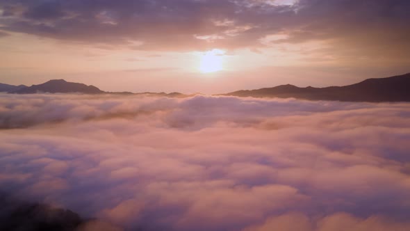 Drone flight over the clouds during sunrise.