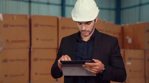 Factory Manager Using Tablet Computer in Warehouse or Factory alt