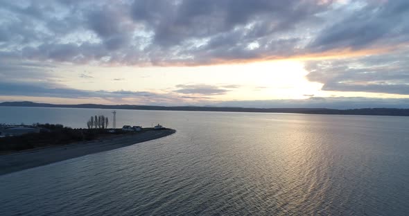 Discovery Park Point Lighthouse Aerial Flyaway From Peninsula At Sunset - Seattle Washington Usa alt