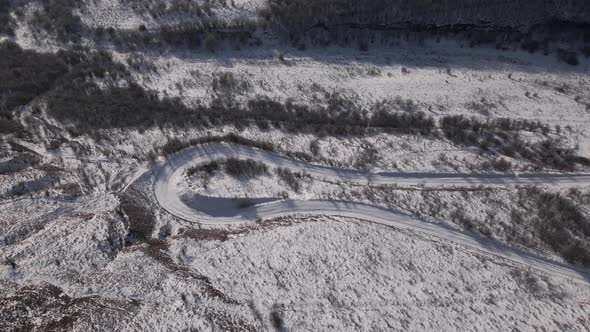 Aerial View of a Snowy Curve Country Road
