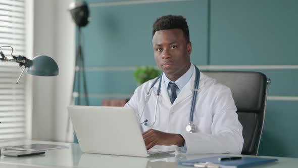 African Doctor Showing No Sign By Finger While Using Laptop in Office alt
