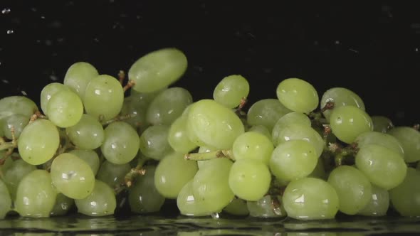 Green Grape Bunch Falls On A Black Background