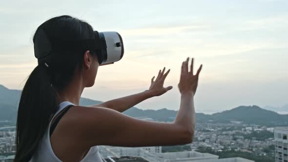 Woman Watching with Virtual Reality Device on Roof Top