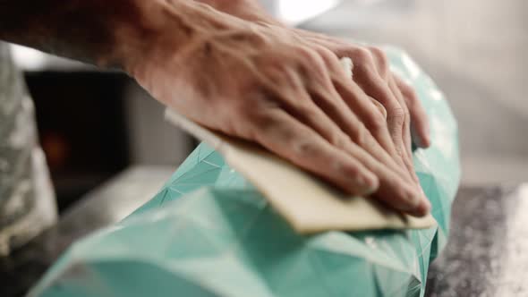 Close-up: a male artisan painter sculptor wipes the product, puts things in order in the workshop alt