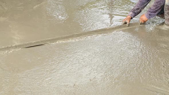 wood trowel working to smooth concrete ground alt