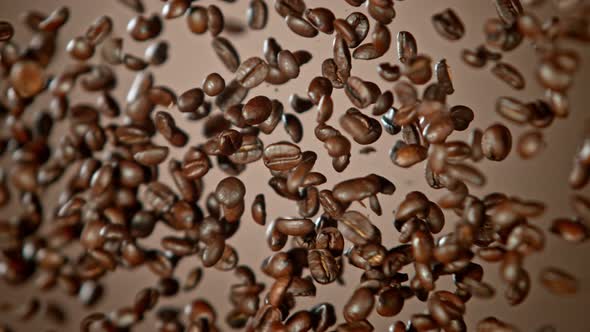 Super Slow Motion Shot of Crashing Coffee Beans on Brown Gradient Background at 1000Fps alt