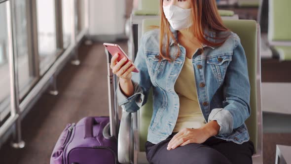 Young Asian woman wearing sergical mask and using smart phone