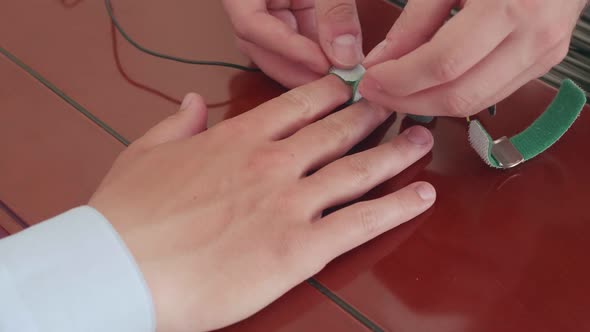 Lie Detector Sensors are Put on a Person's Fingers