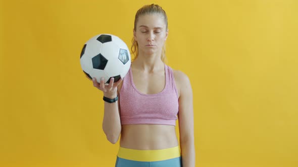 Portrait of Serious Young Woman with Football Showing Red Card Looking at Camera alt