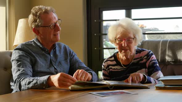 Active senior couple looking at photo album 4k alt