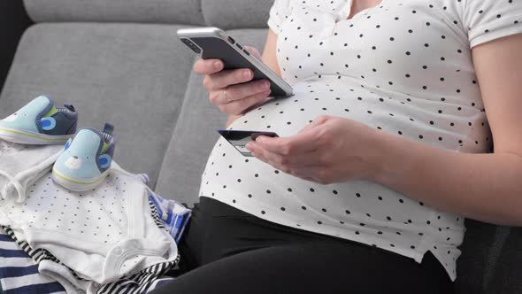 Pregnant Woman on Sofa with Phone and Credit Card