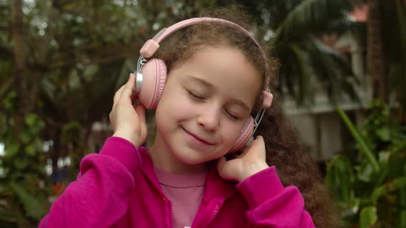 Portrait of Cute Little Child On Relaxing on With Eyes Closed Wearing Headphones alt
