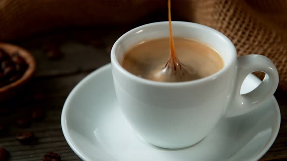Super Slow Motion Shot of Coffee Drop Falling Into Cup of Espresso at 1000 Fps alt