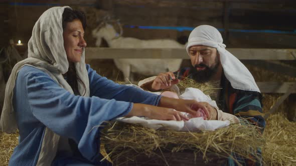 Mary and Joseph Taking Care of Baby Jesus in Inn Stable alt