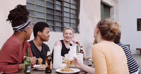 Slow motion shot of friends eating Asian takeaway food outdoors