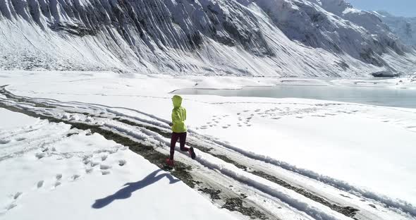 Woman trail runner cross country running in winter nature,Aerial view drone footage  alt