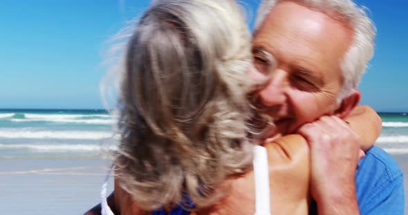Senior couple hugging each other at the beach alt